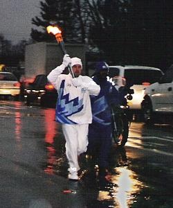 The torch relay of the 2002 Winter Olympics passes through Cincinnati, Ohio.